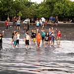 Kinder winken am Strand im ländlichen Indonesien / © Foto: Georg Berg