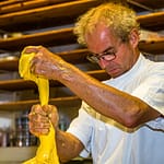 Elastisch, glänzend und gelb. Mit bloßen Händen teilt Arno Antongnini den Vorteig für die unterschiedlichen Panettone-Sorten Tradizionale, Nostrano und Pandananas / © Foto: Georg Berg
