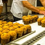 Die kleinen voran! Mini-Panettone verlassen als erstes den Backofen und werden zum Abkühlen auf ein Gestell gespießt / © Foto: Georg Berg