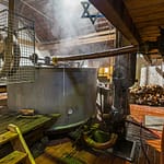 Aus dem Läuterbottich fließt die Zoigl-Würze in eine in den Boden eingelassene Wanne, aus der sie in die Sudpfanne hochgepumpt wird / © Foto: Georg Berg