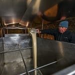 Hausbrauer Wolfgang Üblacker füllt zuerst flüssige Hefe in den Tank, damit sie sich gut mit der Bier-Würze mischt / © Foto: Georg Berg