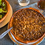 Chef Eric Rousselot bereitet das berühmte Cassoulet Imperial in der Hostellerie Etienne zu, die seit 1956 als Familienbetrieb geführt wird. Die braune Kruste gehört zu einem guten Cassoulet. Des weiteren nur noch ein einfacher Salat und ein Glas Wein - c’est tout - c’est bien! / © Foto: Georg Berg