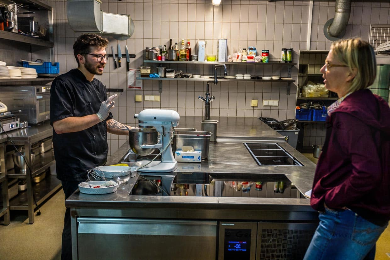 Rotariu Razvan, Koch im St. Peter Stiftskulinarium in Salzburg, erklärt Food-Journalistin Angela Berg, dass es bei der Zubereitung von Salzburger Nockerln vor allem auf eine stabile Masse aus Eischnee und Zucker ankommt / © Foto: Georg Berg
