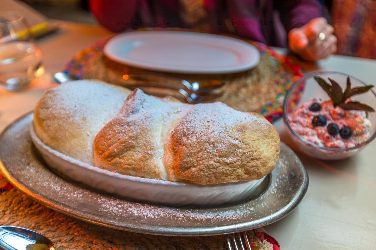 Salzburger Nockerln mit Preiselbeersahne und Puderzucker. Die drei Nocken repräsentieren die drei Salzburger Stadtberge: Kapuzinerberg, Mönchsberg und Rainberg. Salzburger Nockerln werden stets frisch zubereitet und sind ein Soufflé aus Eischnee, Zucker und Eigelb / © Foto: Georg Berg