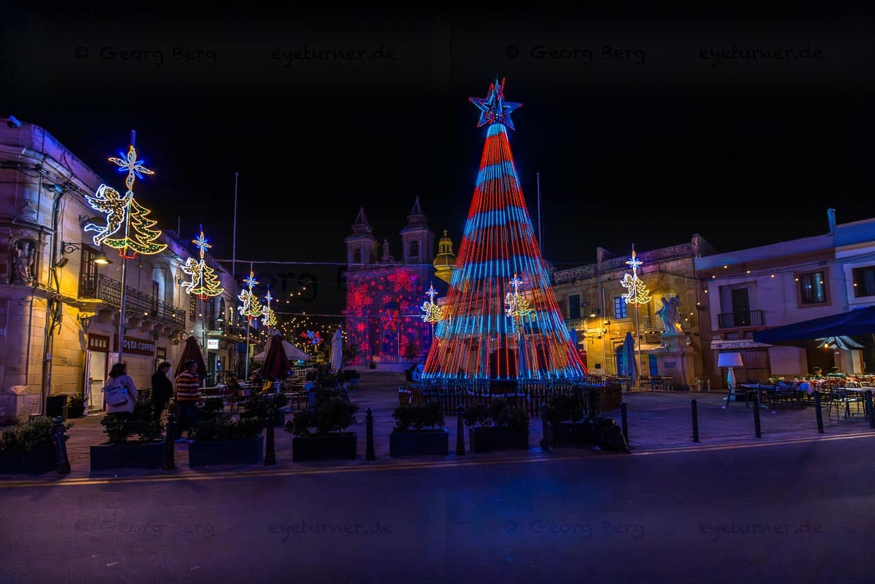 Laserschau an einer Kirchenfassade und leuchtende Weihnachtspyramide. Plätze sind auf Malta vor Weihnachten in buntes Licht getaucht / © Foto: Georg Berg