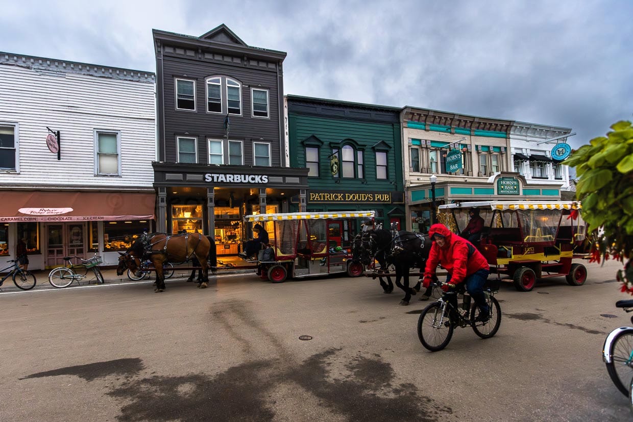 Die Gebäude auf der Hauptstraße erinnern an eine Westernstadt. Hier gibt es Restaurants, Cafés, Souvenirläden und Fudge-Shops. Auf der Straße sind Pferdekutschen, Fahrräder und Fußgänger unterwegs / © Foto: Georg Berg