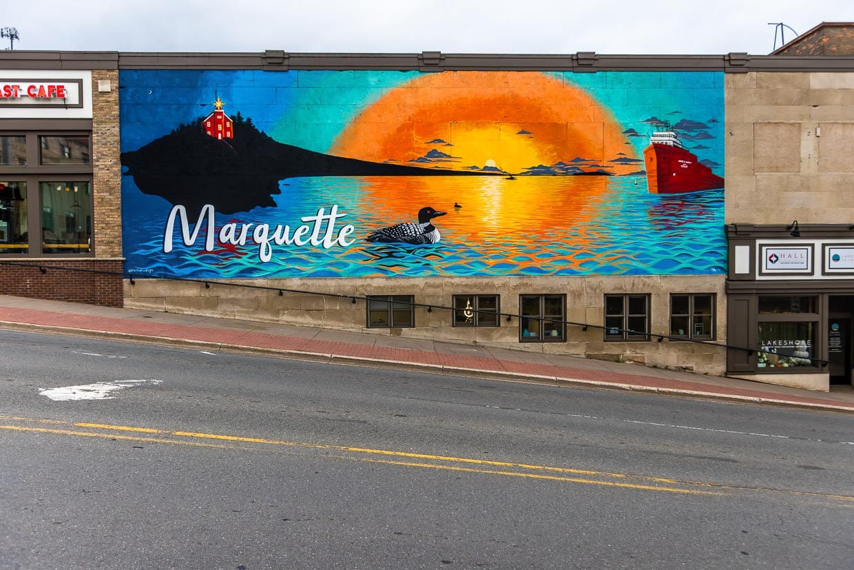 Wandbild in der Stadt Marquette zeigt den 1853 erbauten Leuchtturm und einen Erzfrachter im Sonnenuntergang / © Foto: Georg Berg