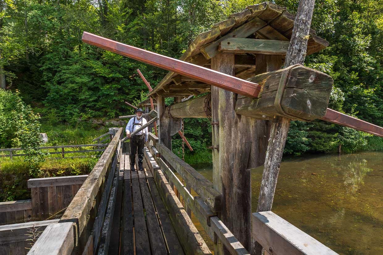 Flößer Martin Spang von der Flößerzunft Oberes Nagoldtal auf der Monhardter Wasserstube. Sie diente als Stauanlage, um die Flößer bei der Holztrift zu unterstützen. Bäche wurden angestaut, damit genug Wasser vorhanden war, um große Mengen Holz als Flöße aus dem Schwarzwald in entfernte Gebiete abtransportieren zu können. Diese Mechanik war ein zentraler Bestandteil der Flößerei, die fast 500 Jahre lang ein bedeutendes Gewerbe im Schwarzwald war / © Foto: Georg Berg