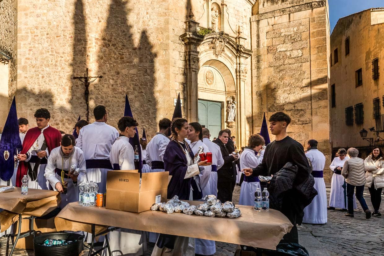 Before the Procession of Forgiveness (Procesión del Perdón), numerous members of the Hermandad del Bautismo de Nuestro Señor Jesucristo fortify themselves in front of the church of San Pedro. Hornazo, a bread filled with ham, chorizo and egg, is the typical marching food of the costaleros / © Photo: Georg Berg