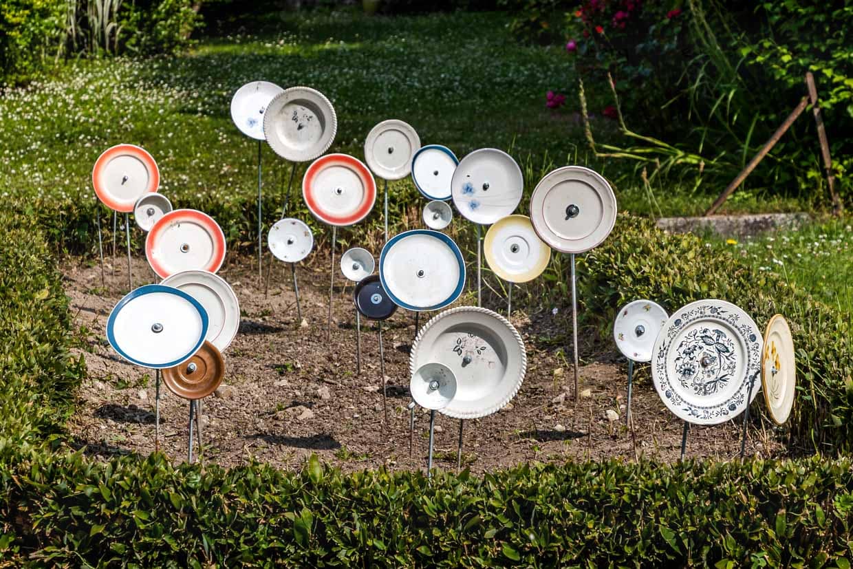 Plate on sticks in a front garden in France, Nouvelle-Aqutaine. The motif fits in with the German saying 