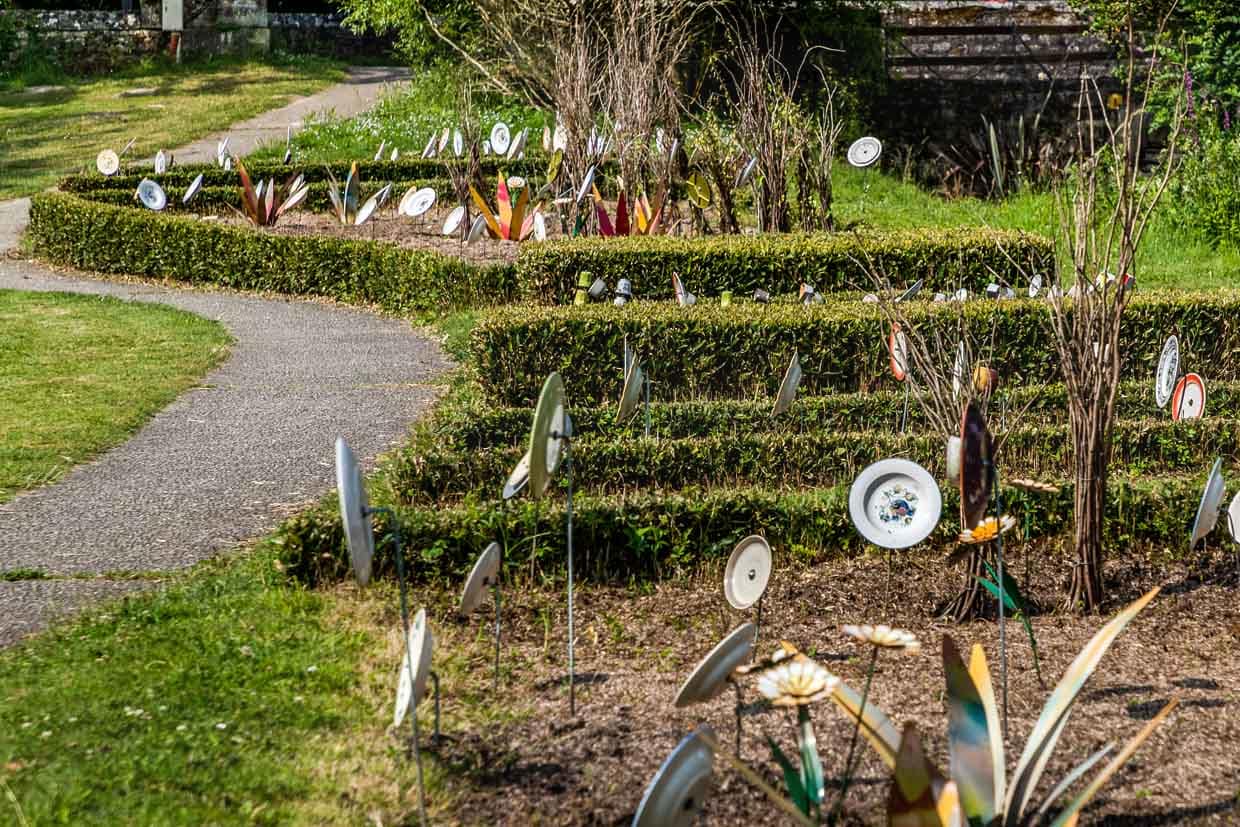 Plate on sticks in a front garden in France, Nouvelle-Aqutaine. The motif fits in with the German saying 