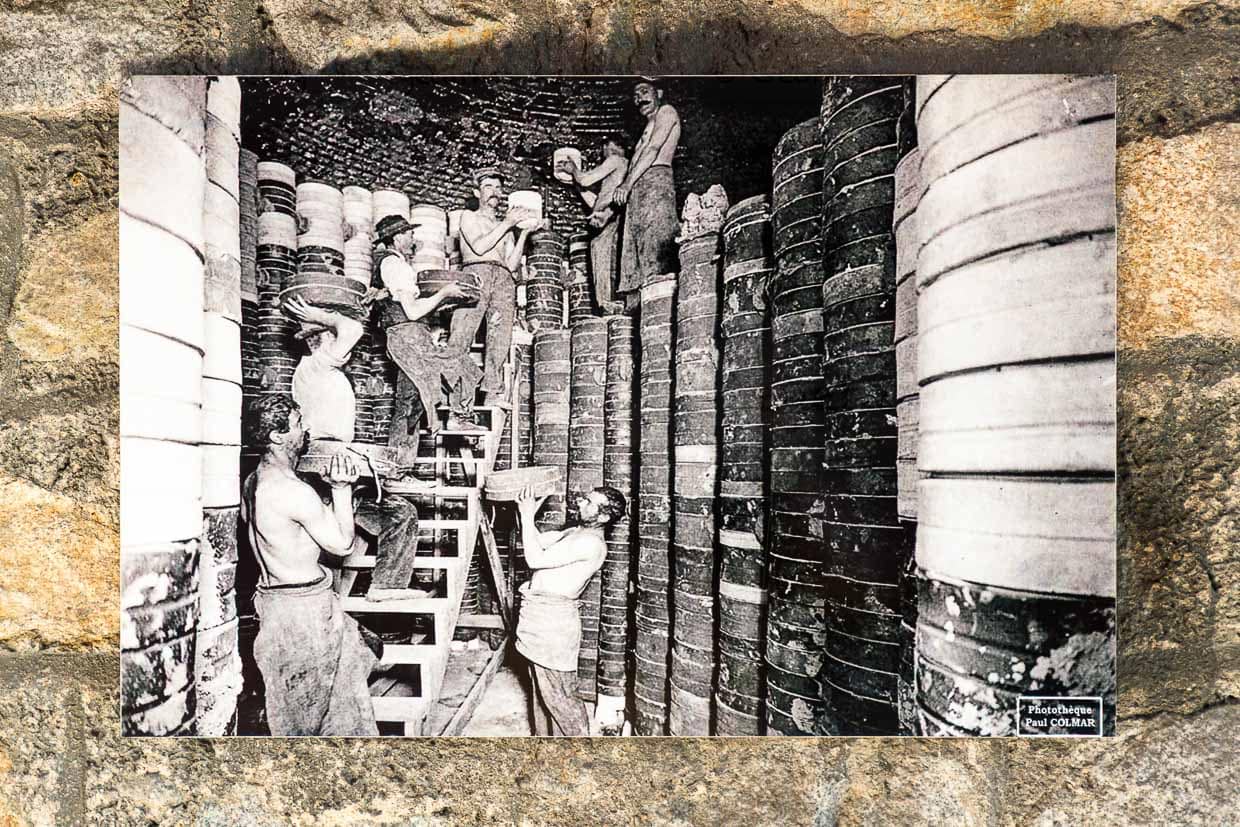 Alte Postkarte aus dem Museum Four des Casseaux in Limoges zeigt ein Foto von Paul Colmar: Fabrikarbeiter packen den Ofen für den zweiten Brand, die schweren Tonformen, in denen jeweils ein Porzellanrohling liegt, wurden meterhoch in den großen Ofen gestapelt / © Foto: Georg Berg