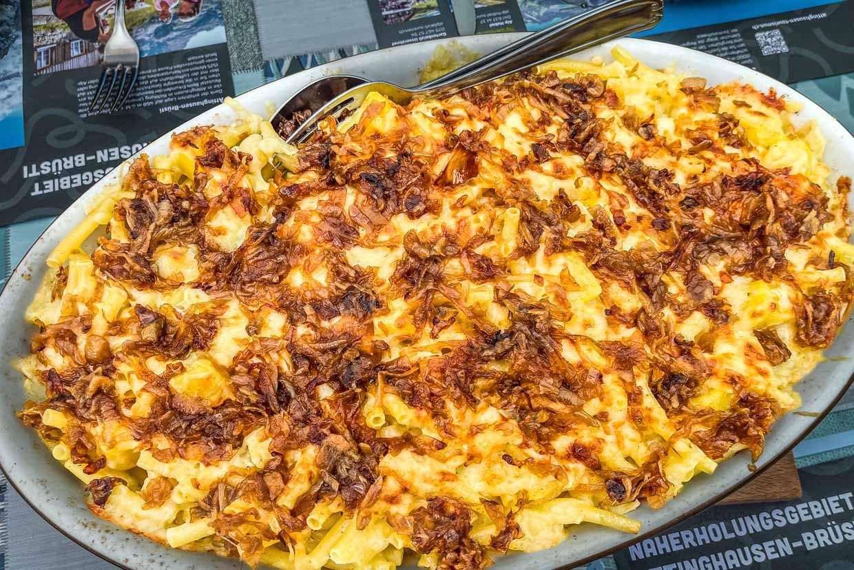 Älplermagronen auf der Hobiel Alp. Ein klassisches Gericht aus Kartoffeln, Nudeln, Zwiebeln und reichlich Alpkäse, oft mit Apfelmus serviert. Es ist besonders bei Wanderern beliebt, weil es kräftigend und sättigend ist / © Foto: Angela Berg