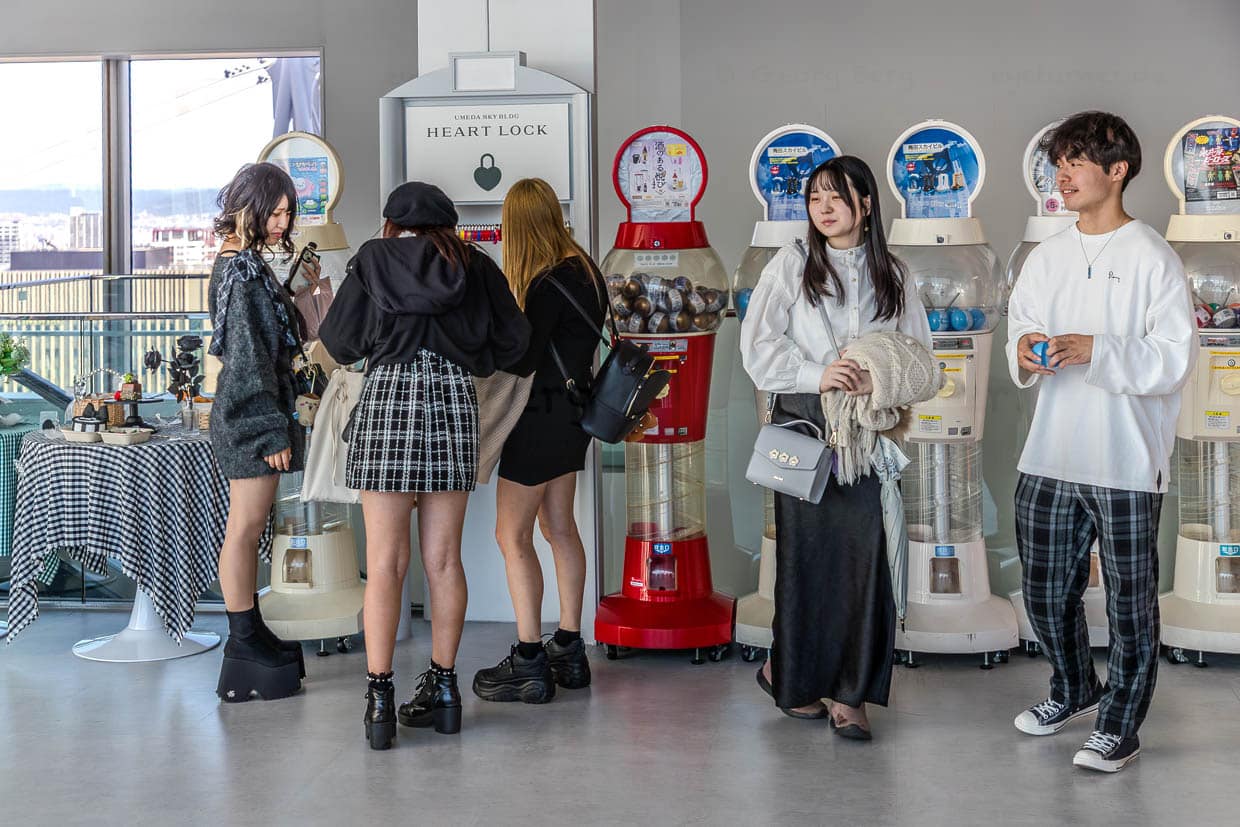 Gachapon-Automaten im Umeda Skybuilding Osaka. Das Kapselspielzeug ist bei Kindern und Jugendlichen beliebt. Die Kugeln enthalten Plastikspielzeug, Sammelfiguren oder kleine Anhänger. Man spricht von einer Gachapon- und Blind-Box-Ökonomie: Tausende Automaten bieten monatlich neue, günstige Mini-Plüschfiguren (200–500 Yen), die speziell für Taschen gemacht sind. Das Sammeln und Tauschen schafft einen Suchtzyklus und senkt die Einstiegshürde / © Foto: Georg Berg