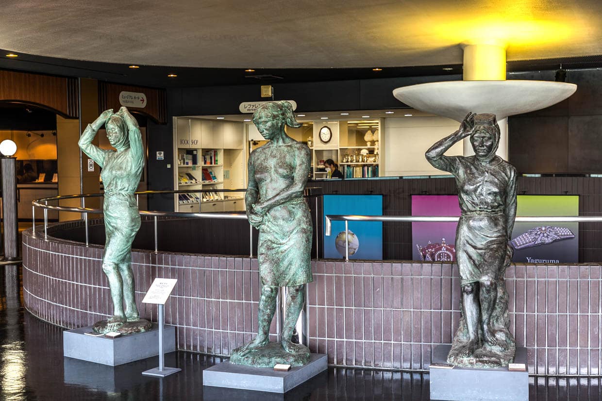 Drei Bronzestatuen von Frauen stehen in einem Museum in Toba, Japan
