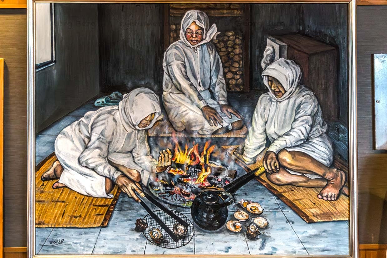 Drei Frauen bereiten Meeresfrüchte über einem Feuer in Shima, Japan zu