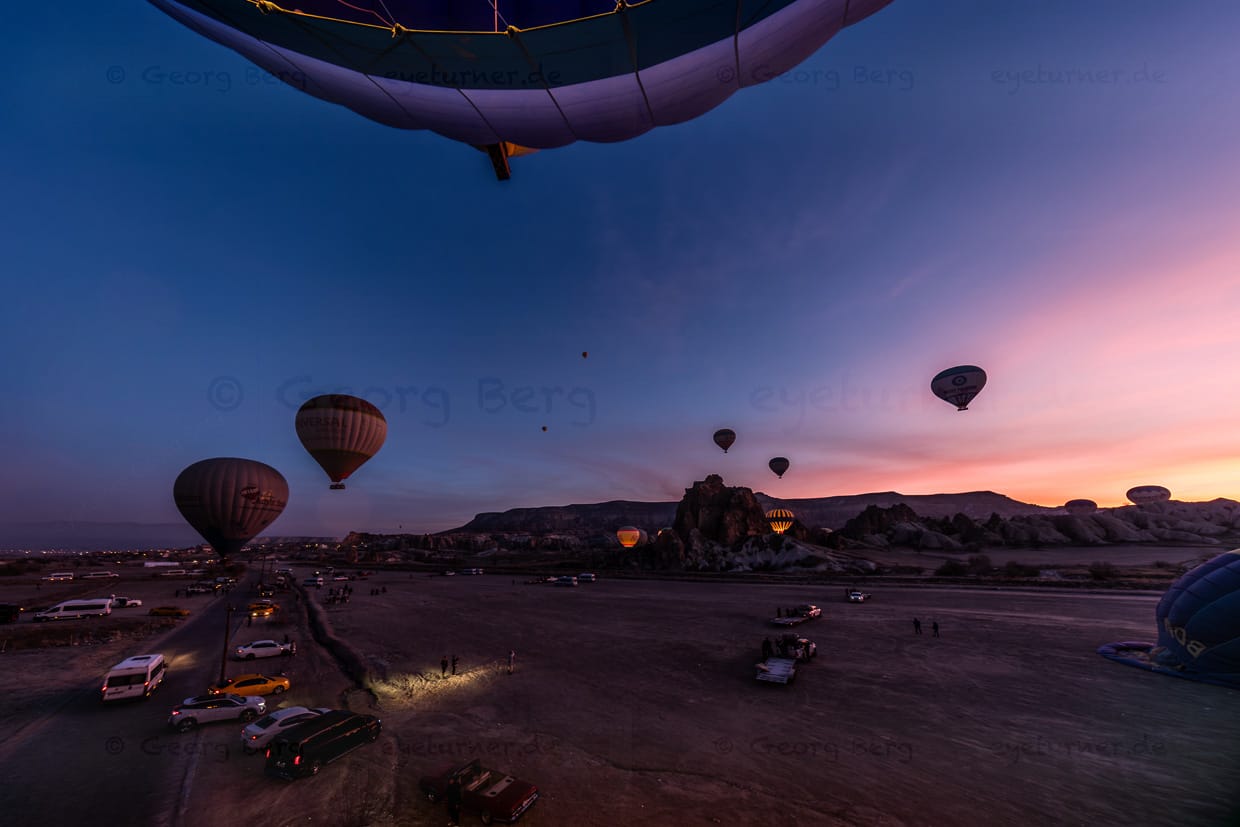 Vor dem Sonnenaufgang steigen Heißluftballons bei Göreme in Kappadokien auf / © Foto: Georg Berg