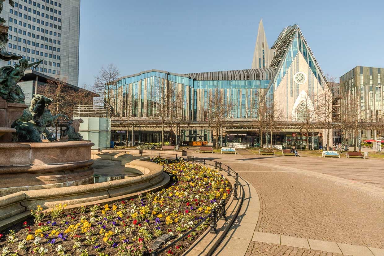 Bunte Blumen blühen vor moderner Architektur am Augustusplatz, Leipzig, Germany