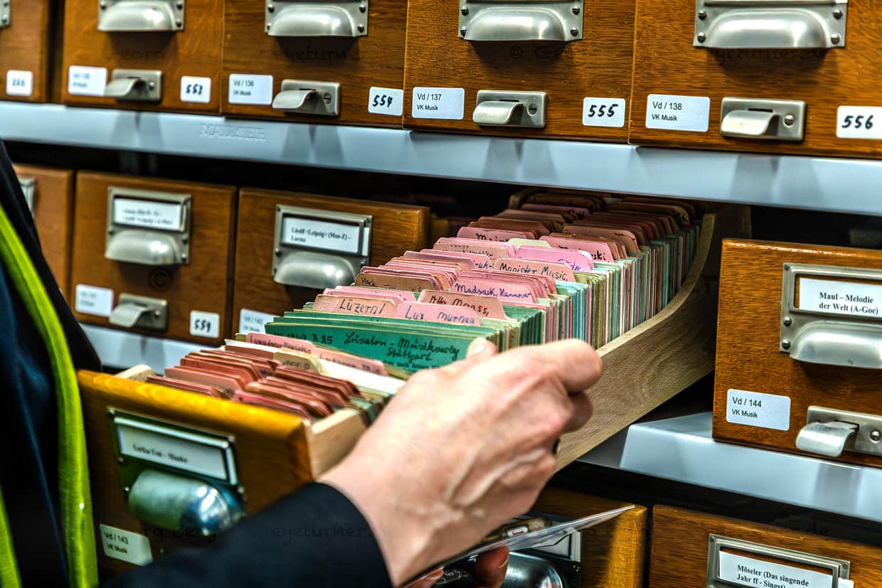 Person durchsucht Karteikarten-Schublade in einem Archiv in Leipzig, Deutschland