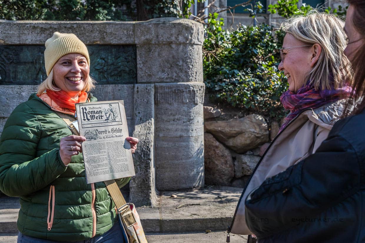 Frau präsentiert eine historische Zeitung in Leipzig, Germany
