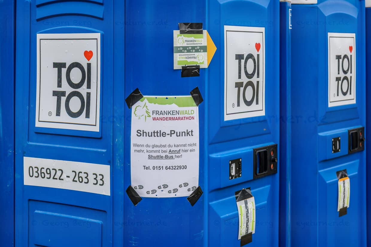 Blaue Toi Toi Miettoiletten mit Hinweisschildern für den Frankenwald Wandermarathon stehen in KC 19, Steinbach am Wald