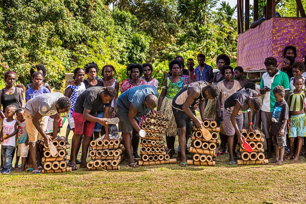 In einer Bamboo-Band werden verschieden lange Bambusrohre rhythmisch mit Flop-Flop-Sohlen angeschlagen / © Foto: Georg Berg