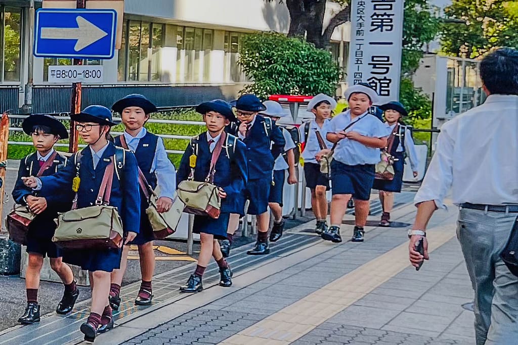 Japanische Mittelstufenschüler in Uniform und noch ohne individuelle Accessoires an der Kleidung / © Foto: Angela Berg