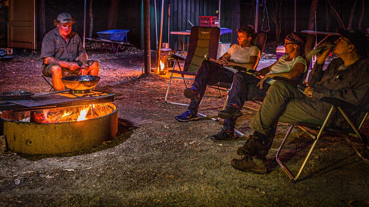 Am Lagerfeuer mit Sab Lord verarbeiten wir die Eindrücke des Tages. In einem Lager, das Sab Lord selbst betreibt, schläft man in fertig aufgebauten Steilwandzelten. Vorher wird das Kanguru-Geschnetzelte mit Gemüse vom Chef persönlich über dem offenen Feuer zubereitet. Gegessen wird dann stilvoll mit Familienerbstücken. Am Lagerfeuer wird der Outback-Macho sentimental und erzählt von seiner Mutter, die ihm das Besteck vermacht hat / © Foto: Georg Berg