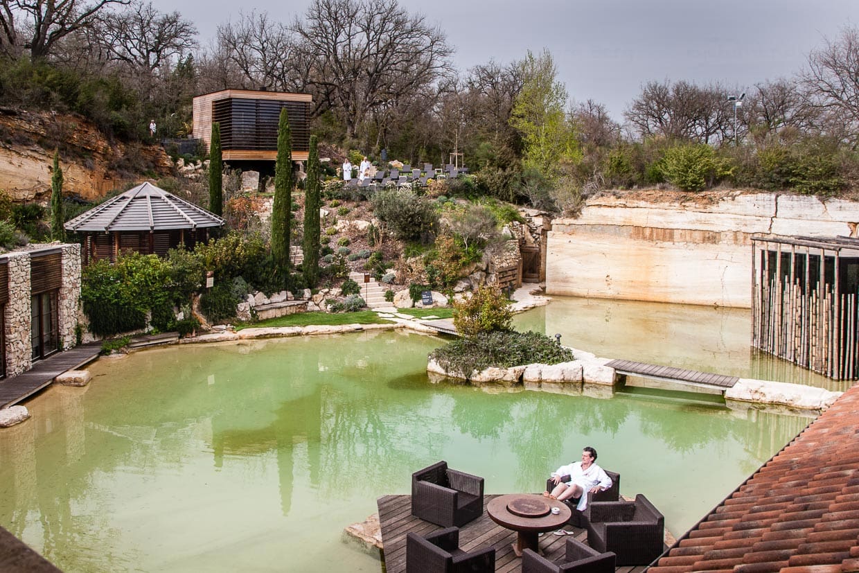 Eine der vielen kleinen Oasen auf dem Gelände des Hotels Adler Thermae. Hier sieht man besonders gut, dass die Anlage in den aufgelassenen Steinbruch gebaut wurde. Die Wand im Hintergrund des Sauna-Gartens ist Travertin-Gestein, das sich auch im Hotel selber oft wiederfindet / © Foto: Georg Berg