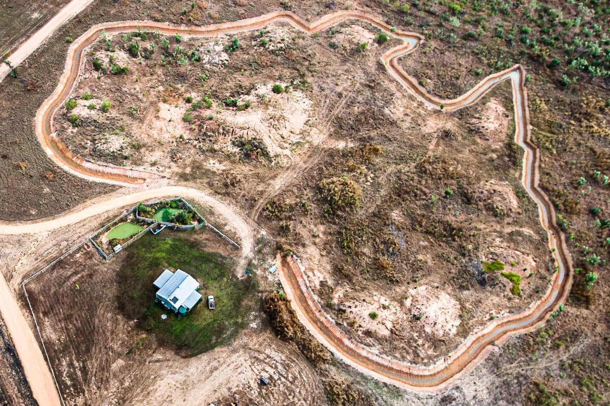 Unter den Kufen des Helikopters eine im Bau befindliche Ferienanlage im Grundriss Australiens / © Foto: Georg Berg