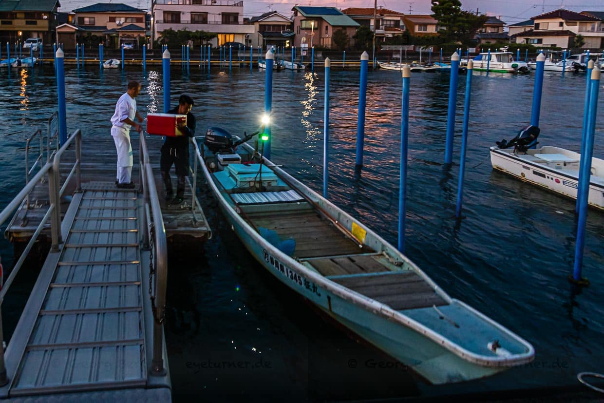 Die Sonne geht gerade unter am Hamana See. Zeit, das Boot mit dem Fischerei-Werkzeug und der Kühlbox für den Fang von Fischen und Krebsen zu beladen / © Foto: Georg Berg