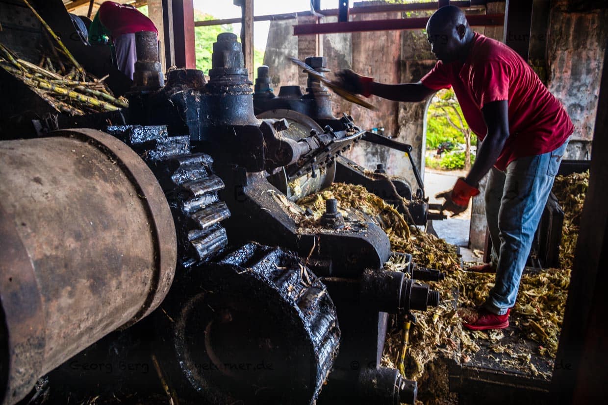 Im laufenden Betrieb werden einzelne Zuckerrohrstücke ein zweites Mal durch die Presse geschickt. Kaum zu glauben, dass diese Maschine schon zu Goethes Zeiten zuverlässig gearbeitet hat / © Foto: Georg Berg