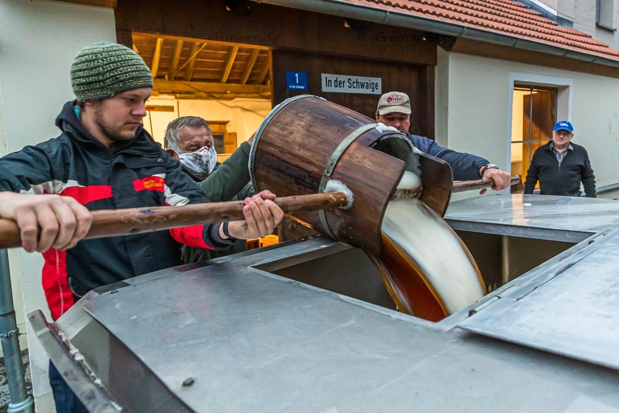 Schwungvoll wird die Zoigl-Stammwürze mit traditionellen Holzeimern in den Tankwagen gefüllt