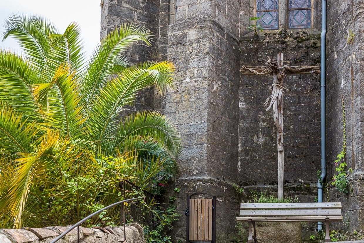 Vor der Kirche von Mourèze steht ein Kreuz, das der Künstler Emmanuel Cometto aus unbearbeitetem Holz geschaffen hat / © Foto: Georg Berg