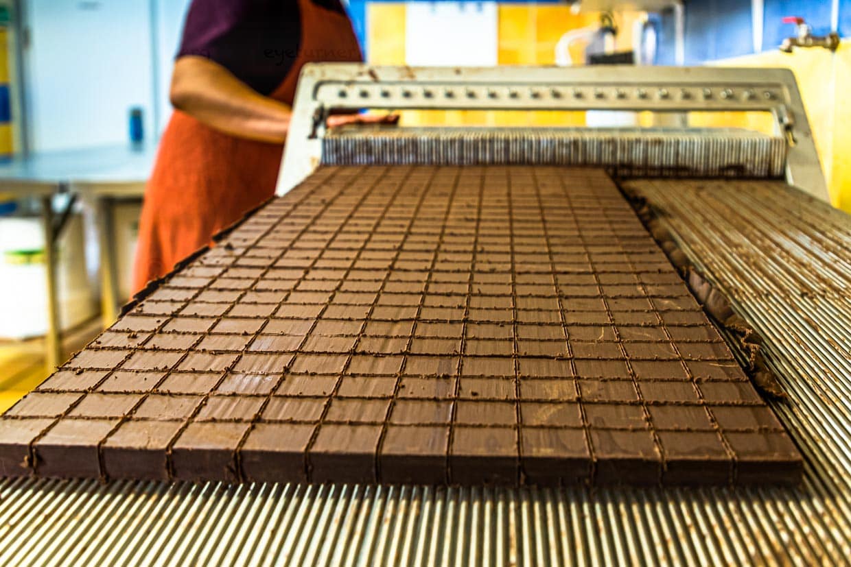Zuschnitt der Nougat-Pralinen in der Chocolaterie Frigoulette. Die geschnittene Praline kommt ohne eine zusätzliche Schokoladenhülle aus. Die Manufaktur aus Beaufort-sur-Gervanne verwendet ausschließlich biozertifizierte und fairtraide gehandelte Kakaobohnen aus Sao Tomé. / © Foto: Georg Berg