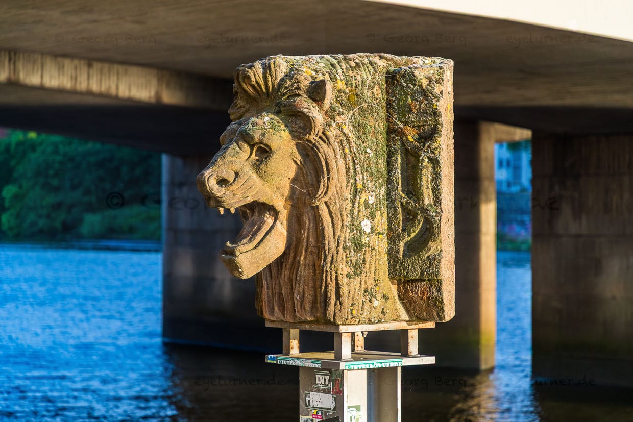 Der Löwenkopf an der Weserpromenade in Bremen erinnert an die Große Weserbrücke von 1893. Die Brücke wurde im April 1945 von den Nazis gesprengt. Der Löwenkopf stürzte ins Wasser / © Foto: Georg Berg