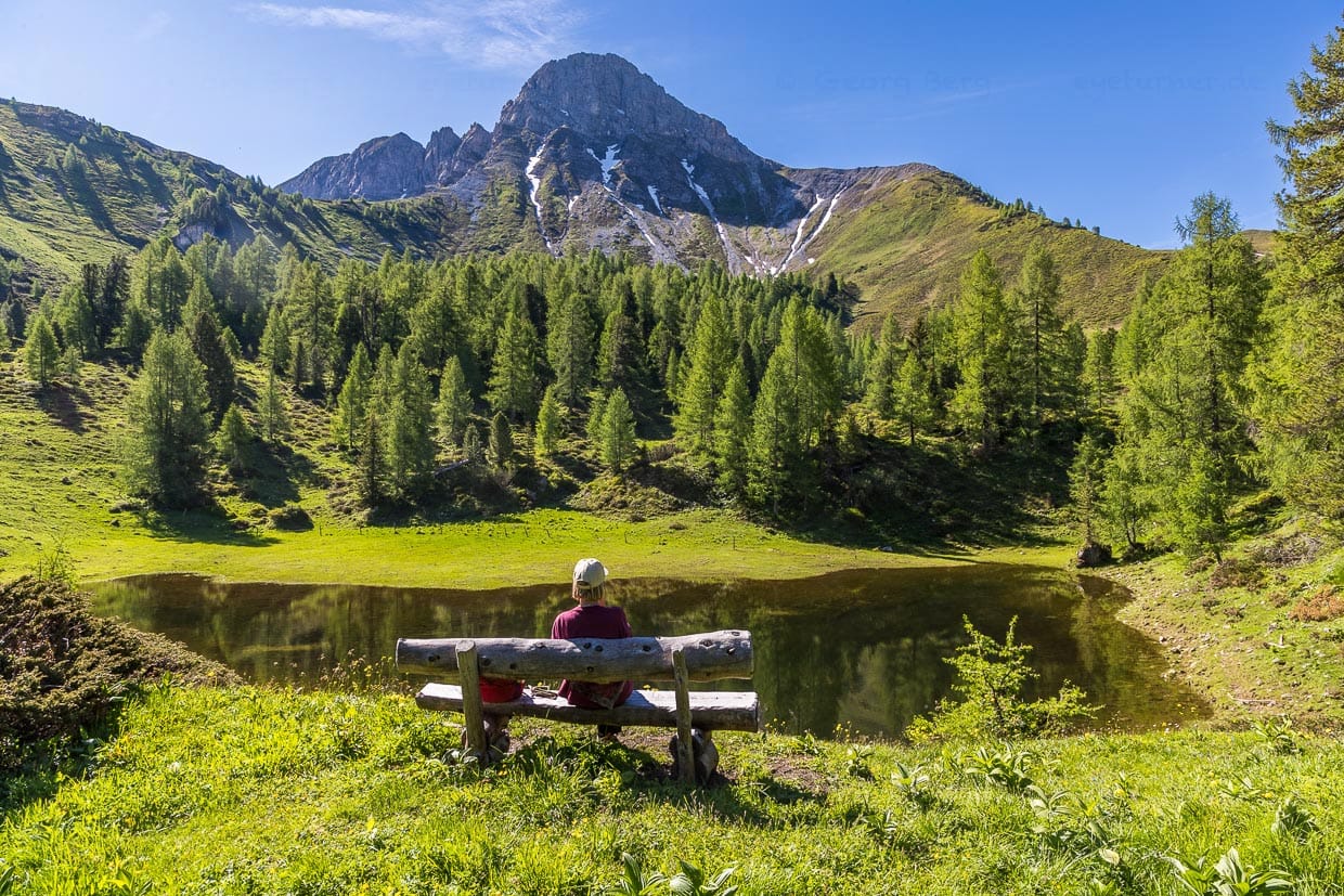Idylle pur auf dem Salzburger Almenweg mit kleinem See, Sitzbank und Blick auf den Draugstein / © Foto: Georg Berg