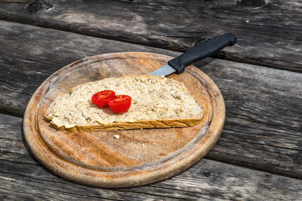 Scheibe Bauernbrot mit Knetkäse auf der Karseggalm im Großarltal. Der Knetkäse wird auf der 400 Jahre alten Alm hergestellt / © Foto: Georg Berg