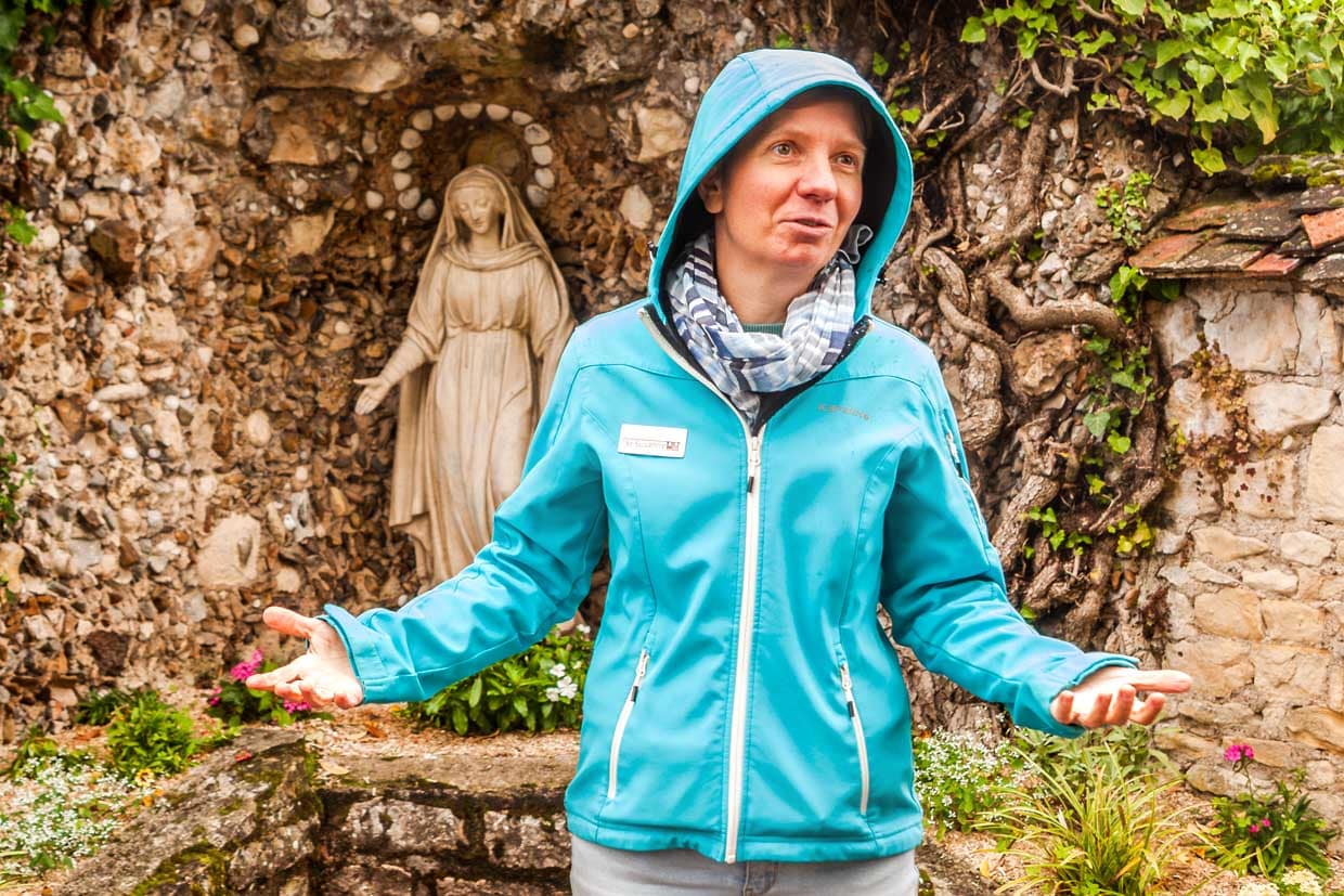 Ordensschwester Susanne Lotter vor dem Lieblingsort der Bernadette Soubirous im Garten der Schwestern von Nevers / © Foto: Georg Berg