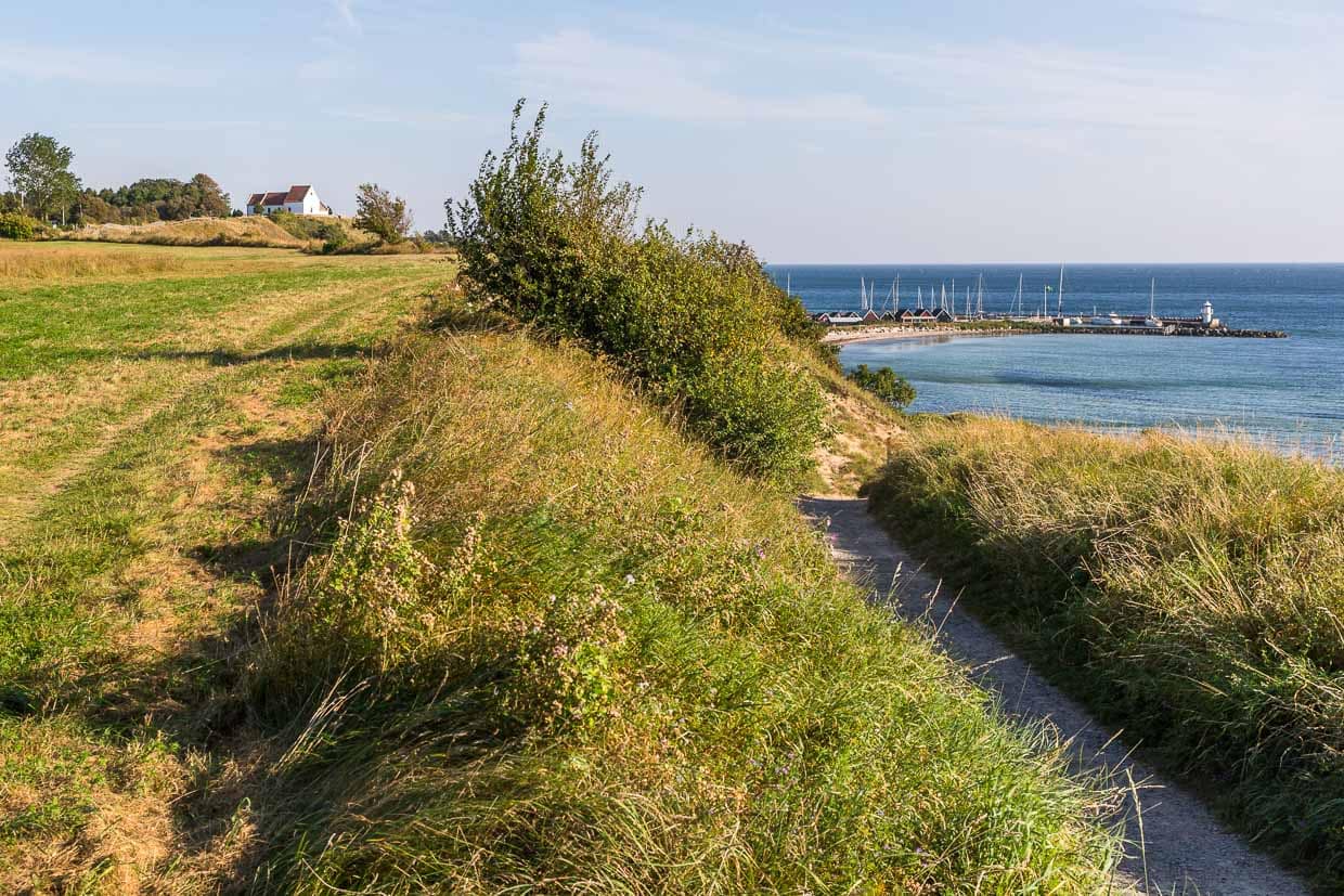 Kirche von Sankt Ibbs auf der Insel Ven mit Hafen und einem Abschnitt des Rad- und Wanderweges, der um die kleine Insel im Öresund führt / © Foto: Georg Berg