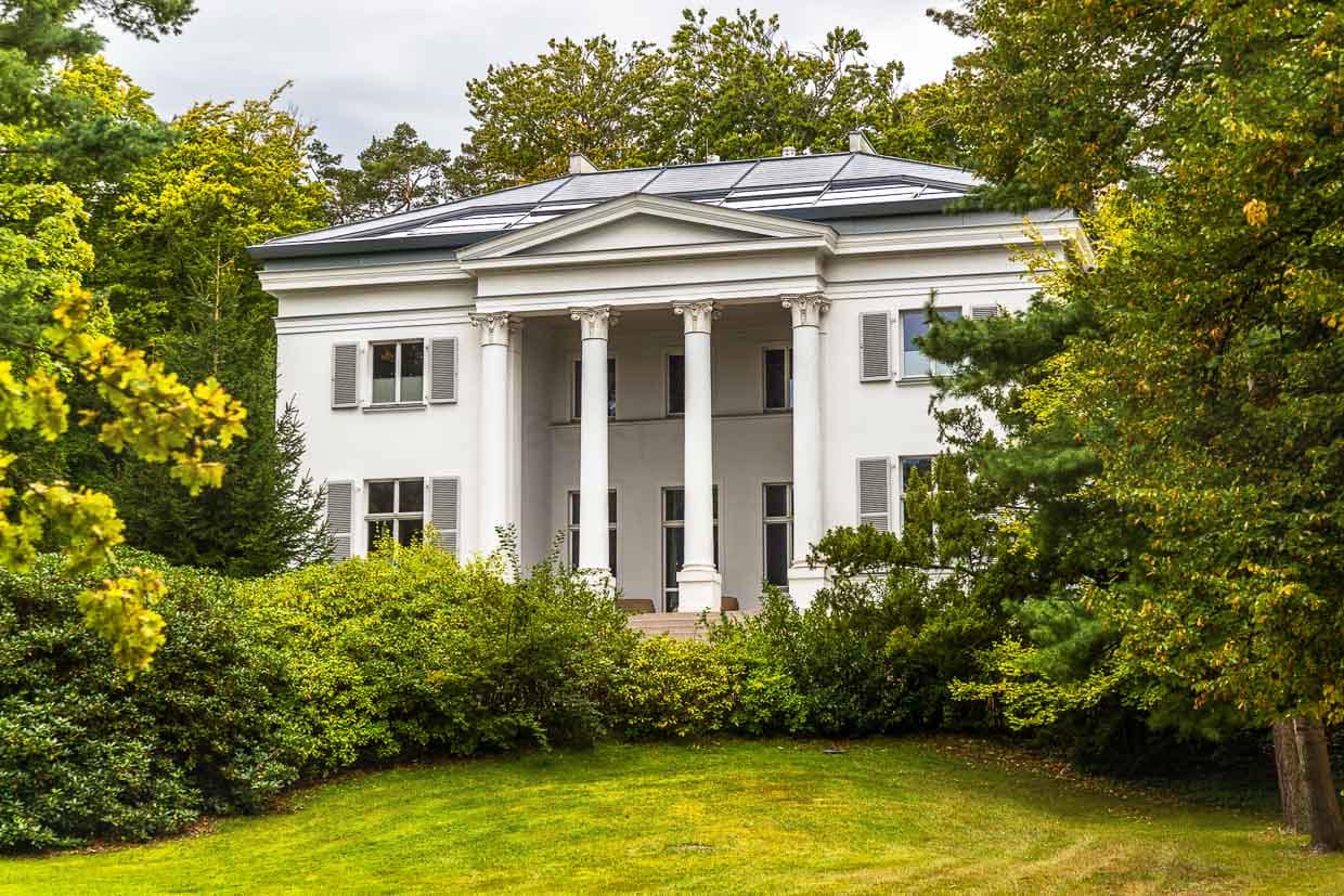 Die neoklassizistische weiße Villa Oppenheim mit vier korinthische Säulen und eine Freitreppe. Sie wurde im Jahr 1883 als Sommerresidenz für die Familie des Bankiers Benoît Oppenheim errichtet. Die Villa Oppenheim war ein beliebtes Motiv des Malers Lyonel Feininger. Zu DDR-Zeiten diente sie dem Minister für Staatssicherheit Erich Mielke als Quartier und repräsentatives Gästehaus. Heute werden in der Heringsdorfer Villa Oppenheim Ferienwohnungen vermietet / © Foto: Georg Berg