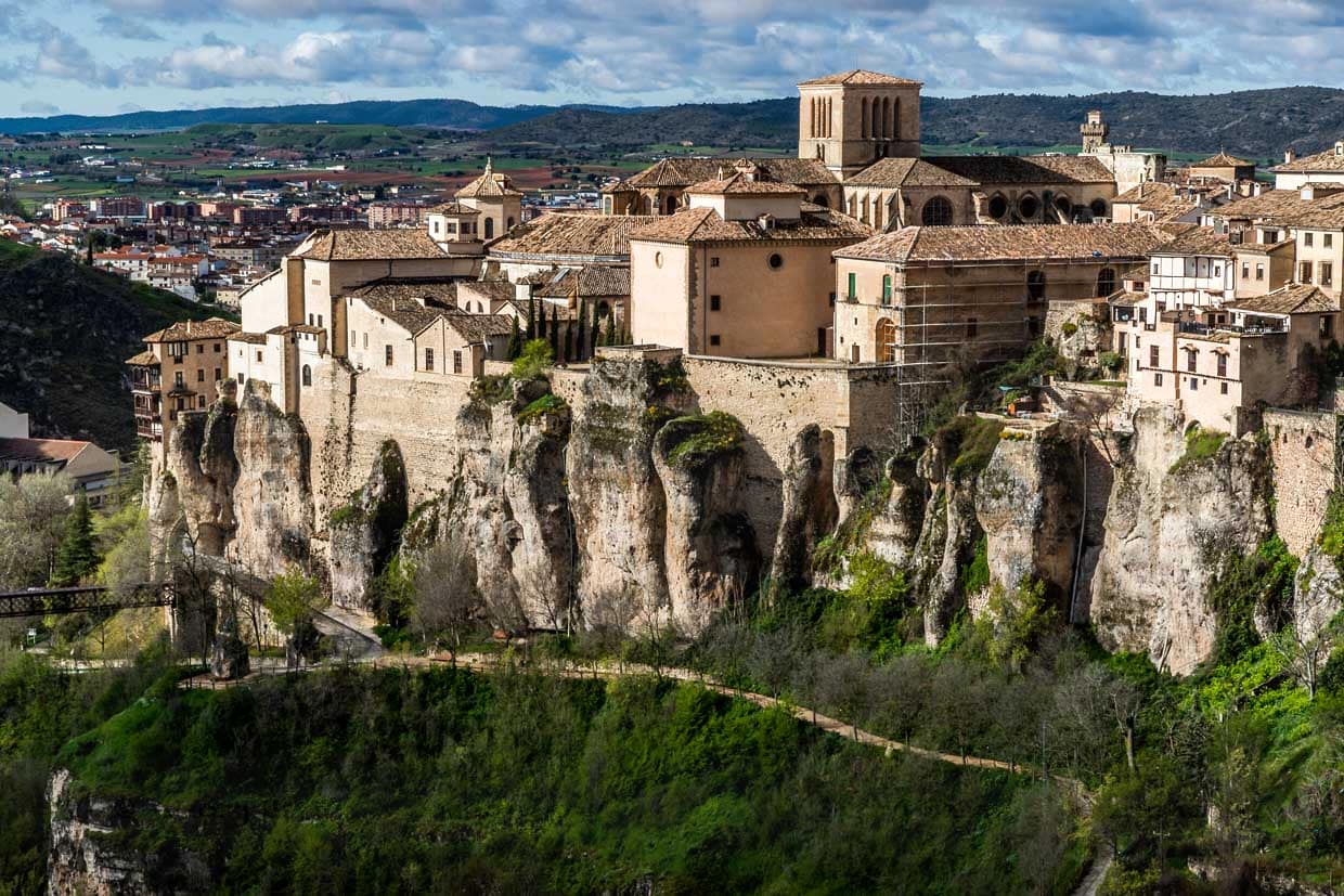 Cuenca liegt eingebettet in eine felsige Landschaft.  Die Altstadt mit der mächtigen Kathedrale ist auf einer Klippe erbaut. Links mit den überdachten Balkonen ist in einem der Casas Colgadas das Museum für Abstrakte Spanische Kunst untergebracht / © Foto: Georg Berg