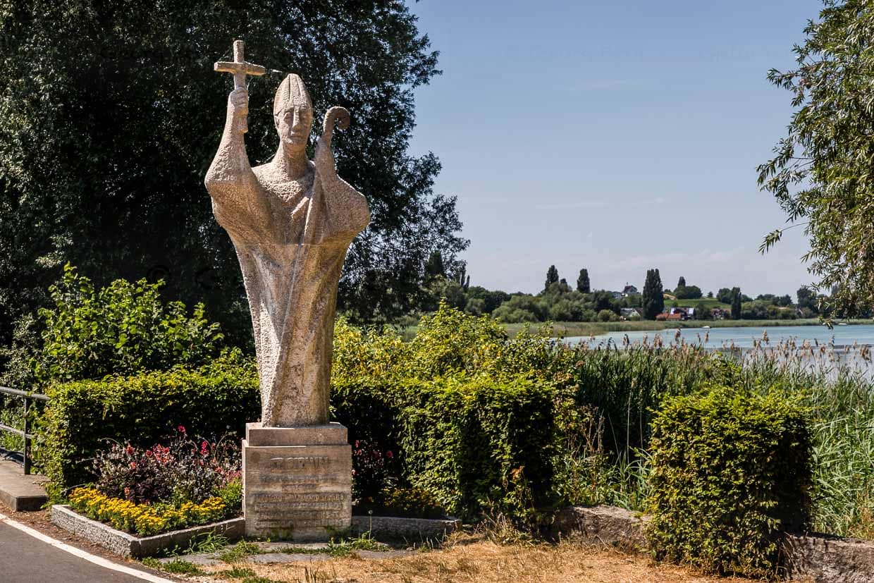 Überlebensgroße Statue von Bischof Pirmin am Bruckgraben, nahe dem Übergang vom Festland zur Insel Reichenau. Sie symbolisiert Pirminius’ Ankunft 724 n. Chr., als er das Kloster gründete und die Insel von mythischen Ungeheuern befreite / © Foto: Georg Berg