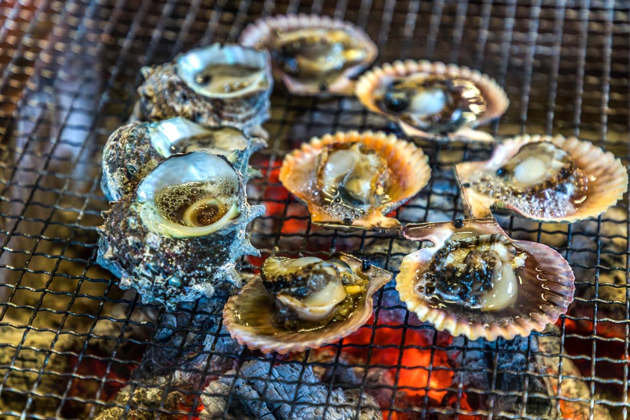 Schalentiere werden über glühender Kohle gegrillt in Shima, Japan