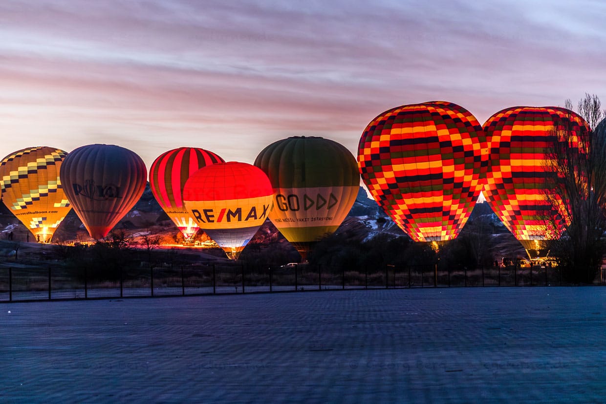 Mehrere Heißluftballons leuchten vor dem Start in Kappadokien / © Foto: Georg Berg