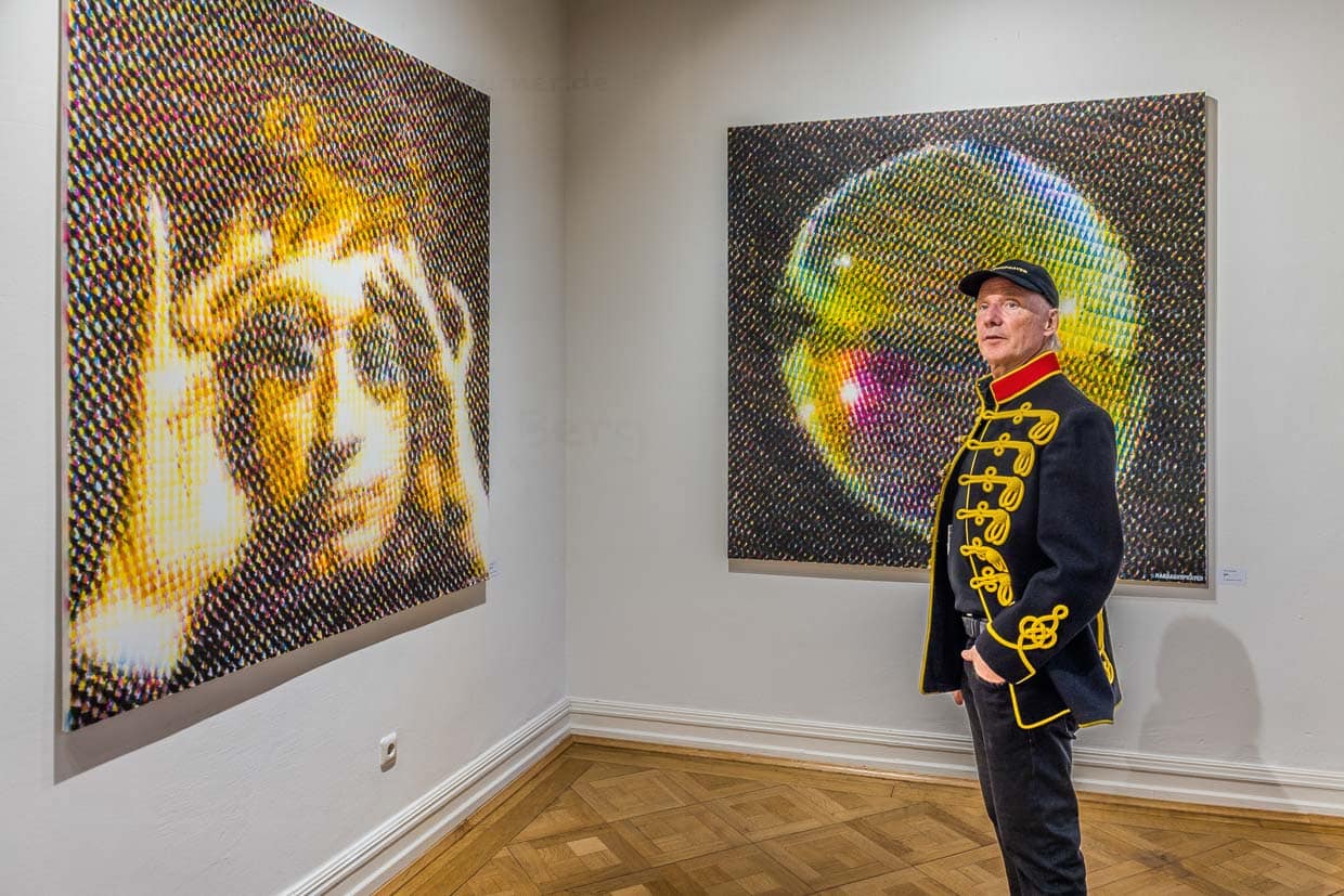 Ein Mann in historischer Uniformjacke betrachtet großformatige Kunstwerke auf der Schanze, Grevenbroich, Deutschland