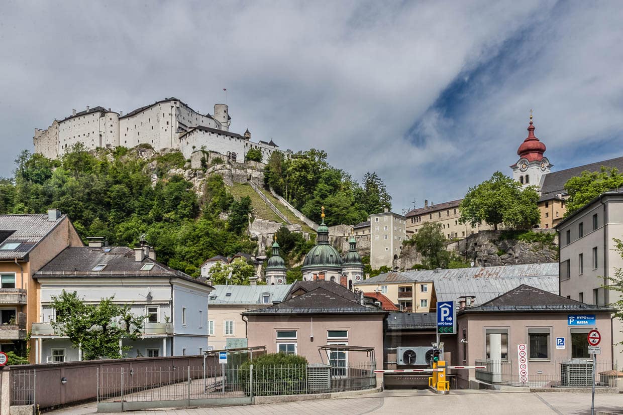 Festung Hohensalzburg und eine Kirche mit roter Kuppel überragen Gebäude und eine HYPO Garage an der Erzabt-Klotz-Straße in Salzburg Austria