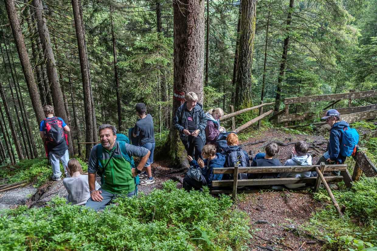 Lachende Wanderer genießen eine Pause im Wald am Wasserfallrundweg Untersulzbach Rosental Austria