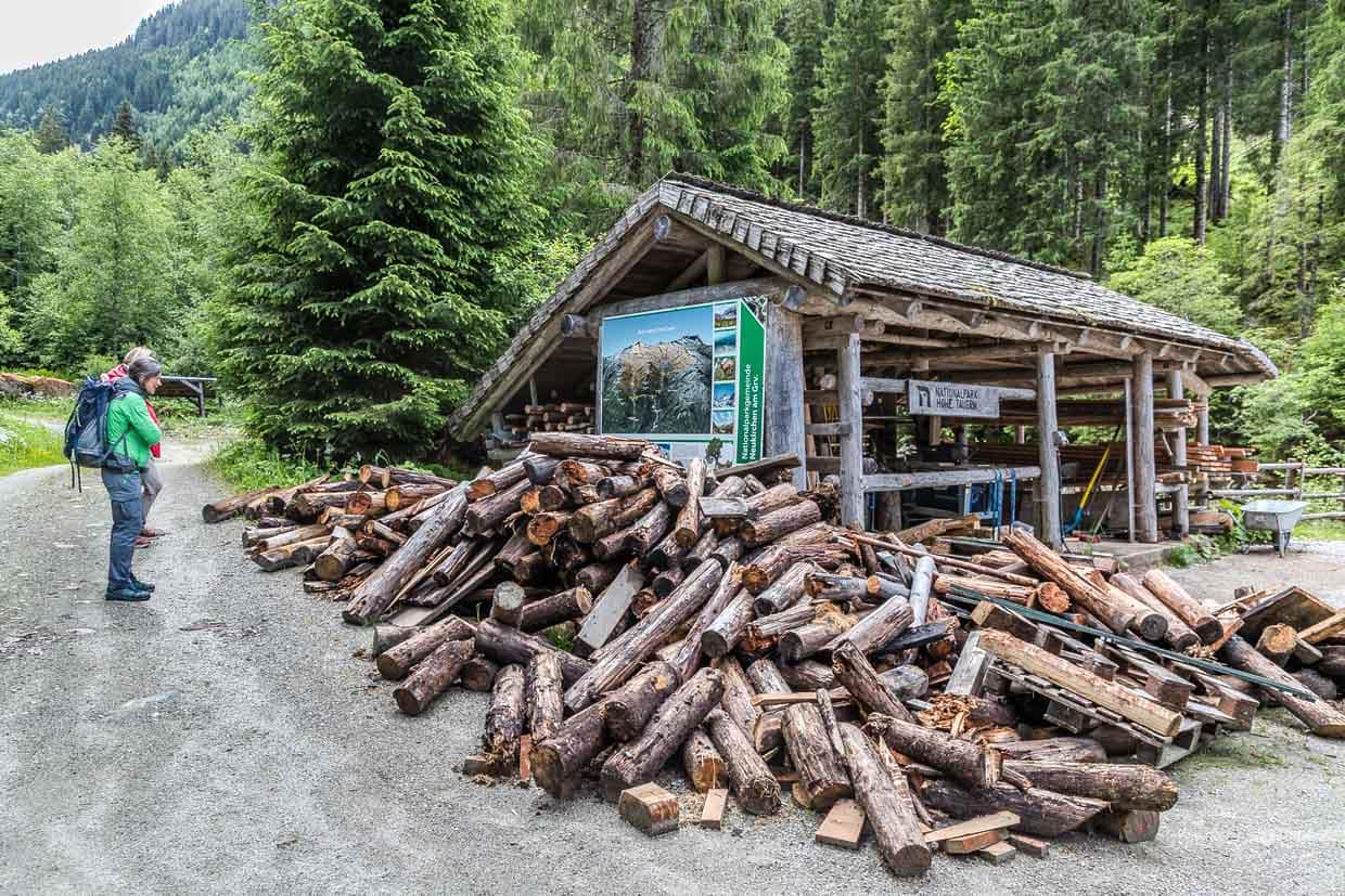 Zwei Wanderer stehen an der Knappenhütte am Wasserfallrundweg Untersulzbach, Alte Holzstempel wurden gegen neue, vor Ort zugeschnitte Holzbalken ausgetauscht
