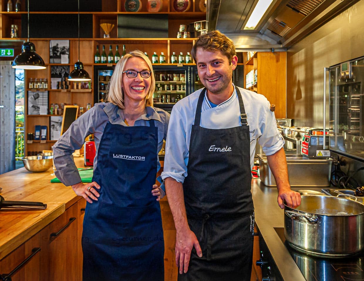 Koch Felix Groß in der offenen Küche des Ernerle mit Redakteurin Angela Berg. Im Hintergrund Regale voll mit regionalen Spezialitäten / © Foto: Georg Berg